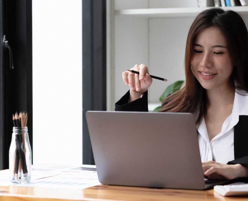 business-asian-woman-using-laptop-for-do-math-finance-on-wooden-desk-in-office-tax-accounting.jpg